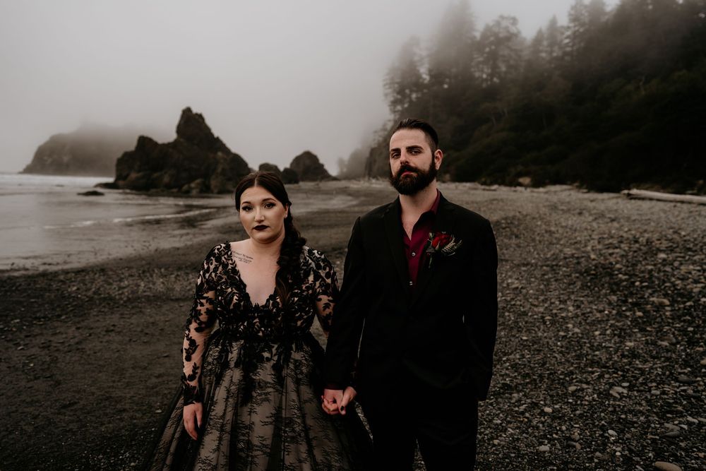 Couple holding hands at ruby beach wearing all black after their elopement at Olympic National Park.
