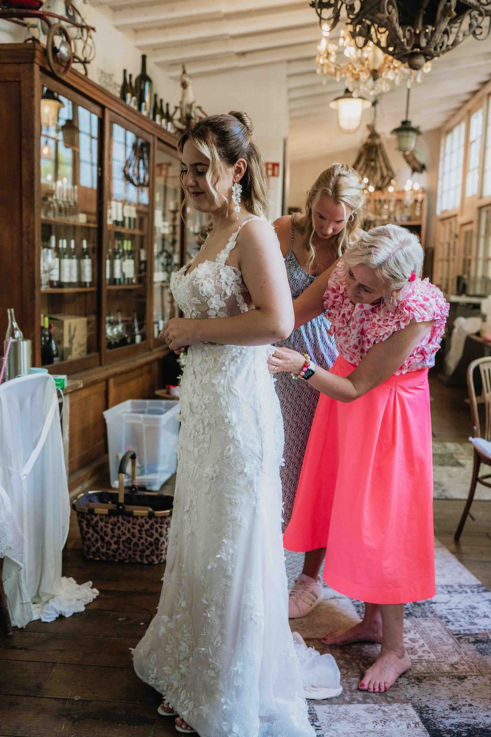 Wedding preparation scene in an elegant venue with chandeliers and wood paneling.