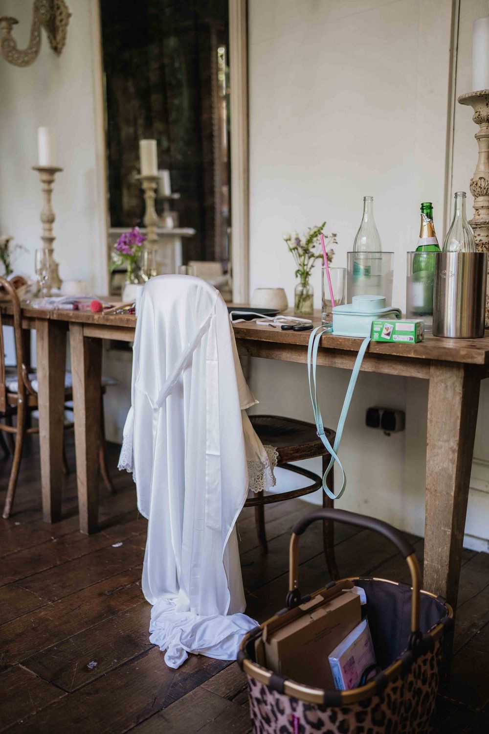 Table setting with white linens and vintage decor in rustic wedding venue.