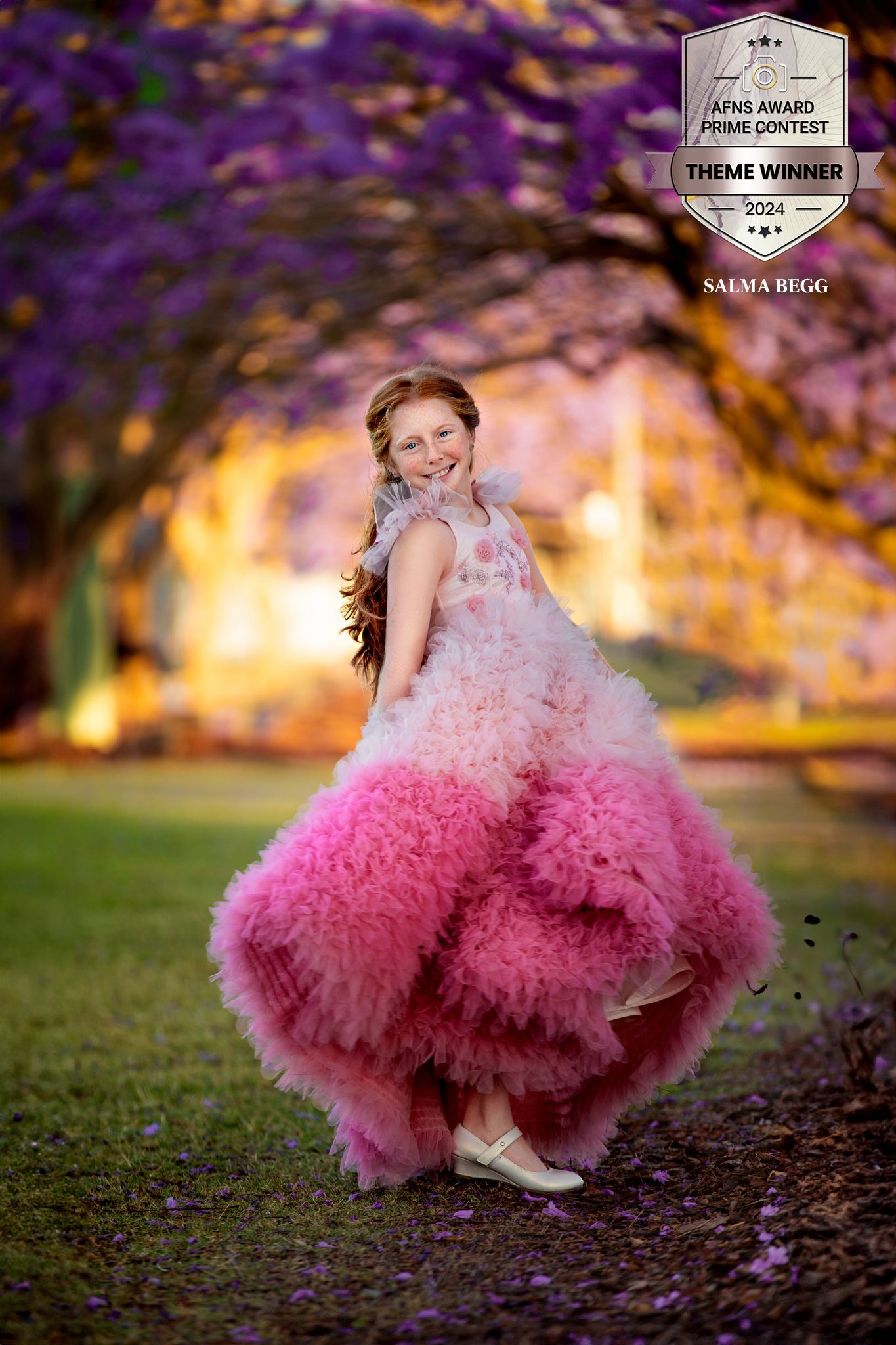 A twirling pink ombre ballgown dress photographed outdoors with purple flowers and warm sunset lighting in the background. award winning mil