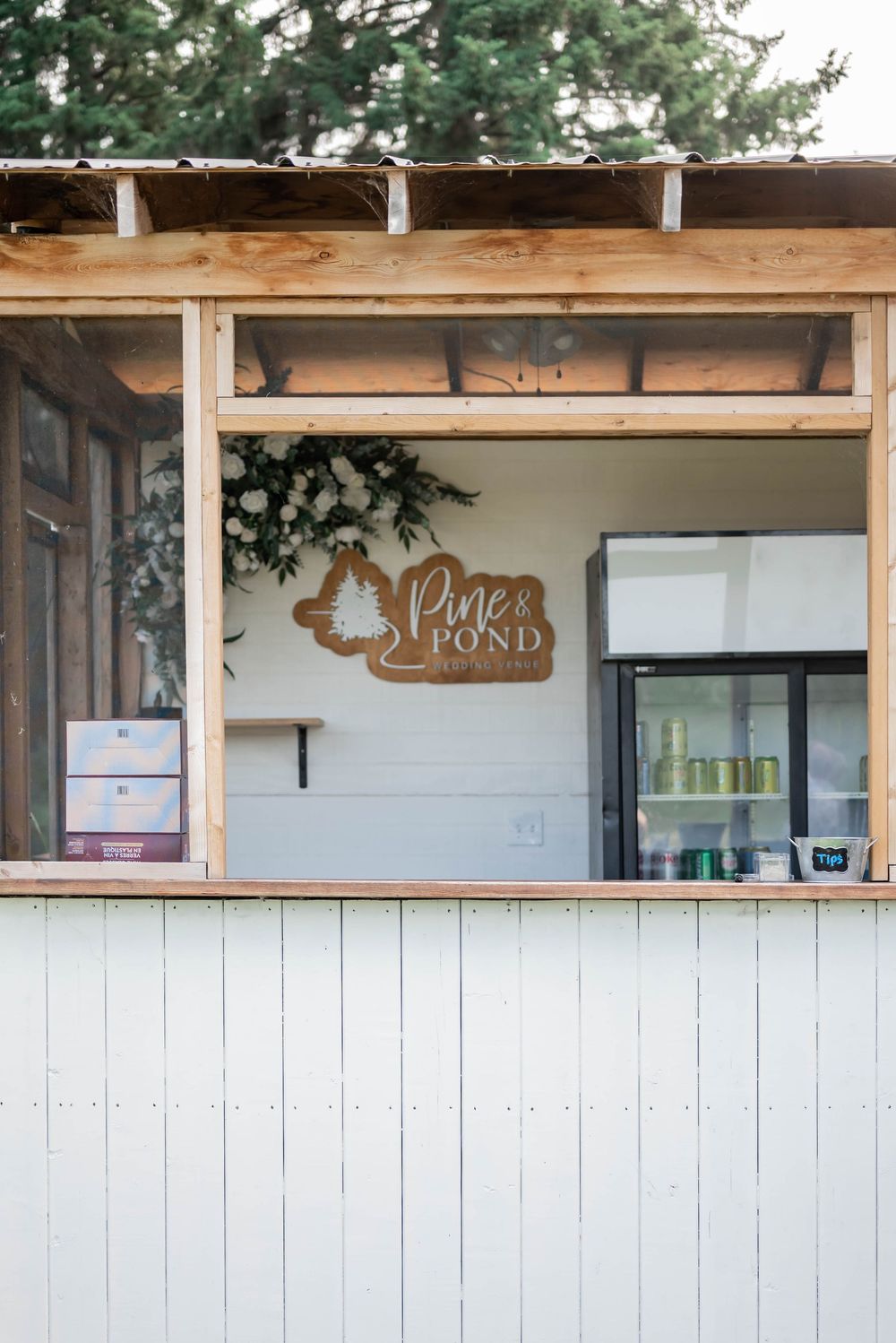 A series of wooden-framed service windows with light blue panels create a rustic, farmhouse-style exterior design.