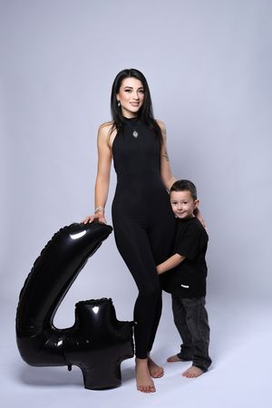 Studio portraits with large black number prop against light gray background.