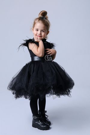 Studio portraits featuring black tulle dress against light gray background.