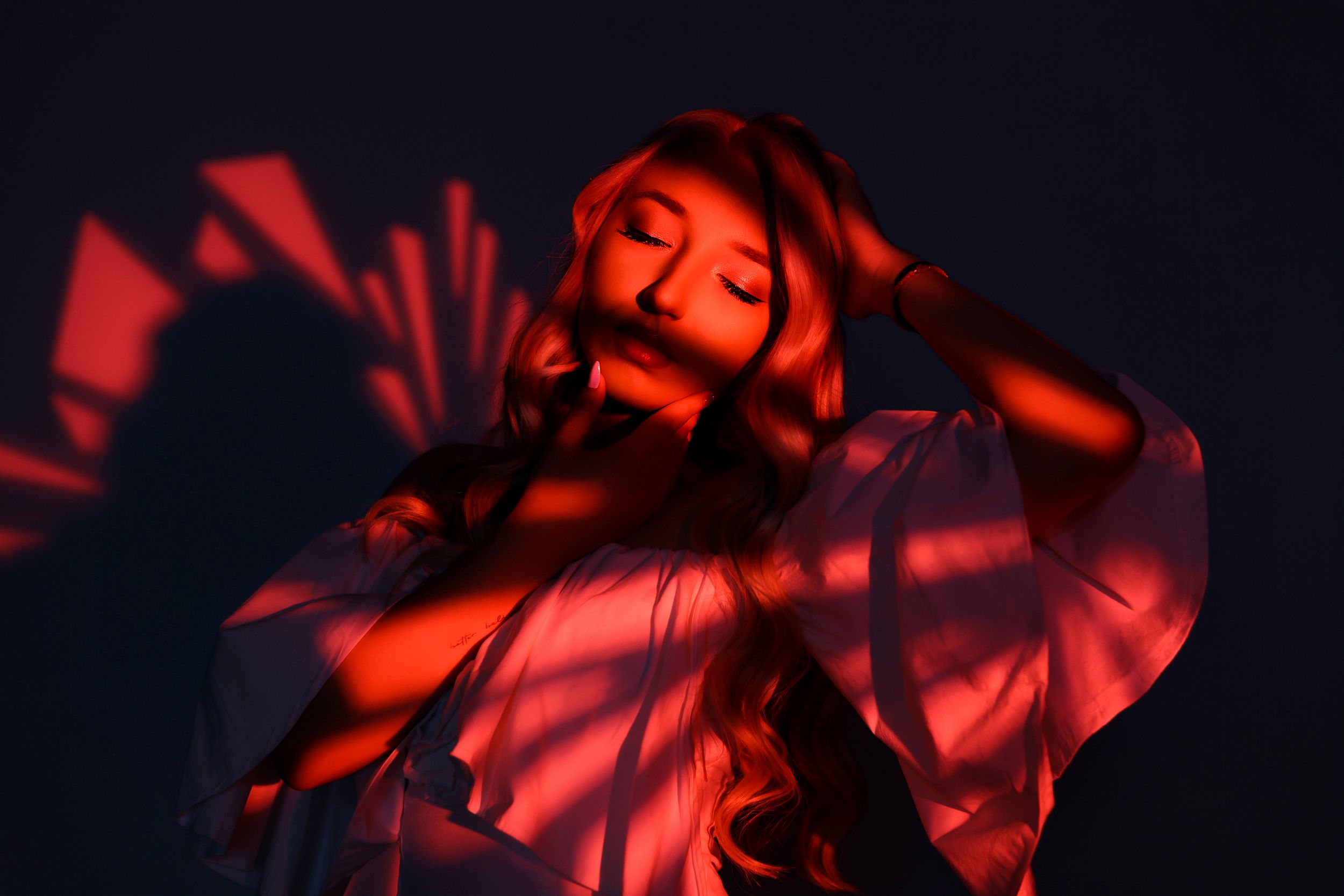 Red dramatic lighting on abstract shapes creating dynamic shadows and patterns.