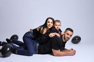 Family portrait session with casual poses on light gray studio background.