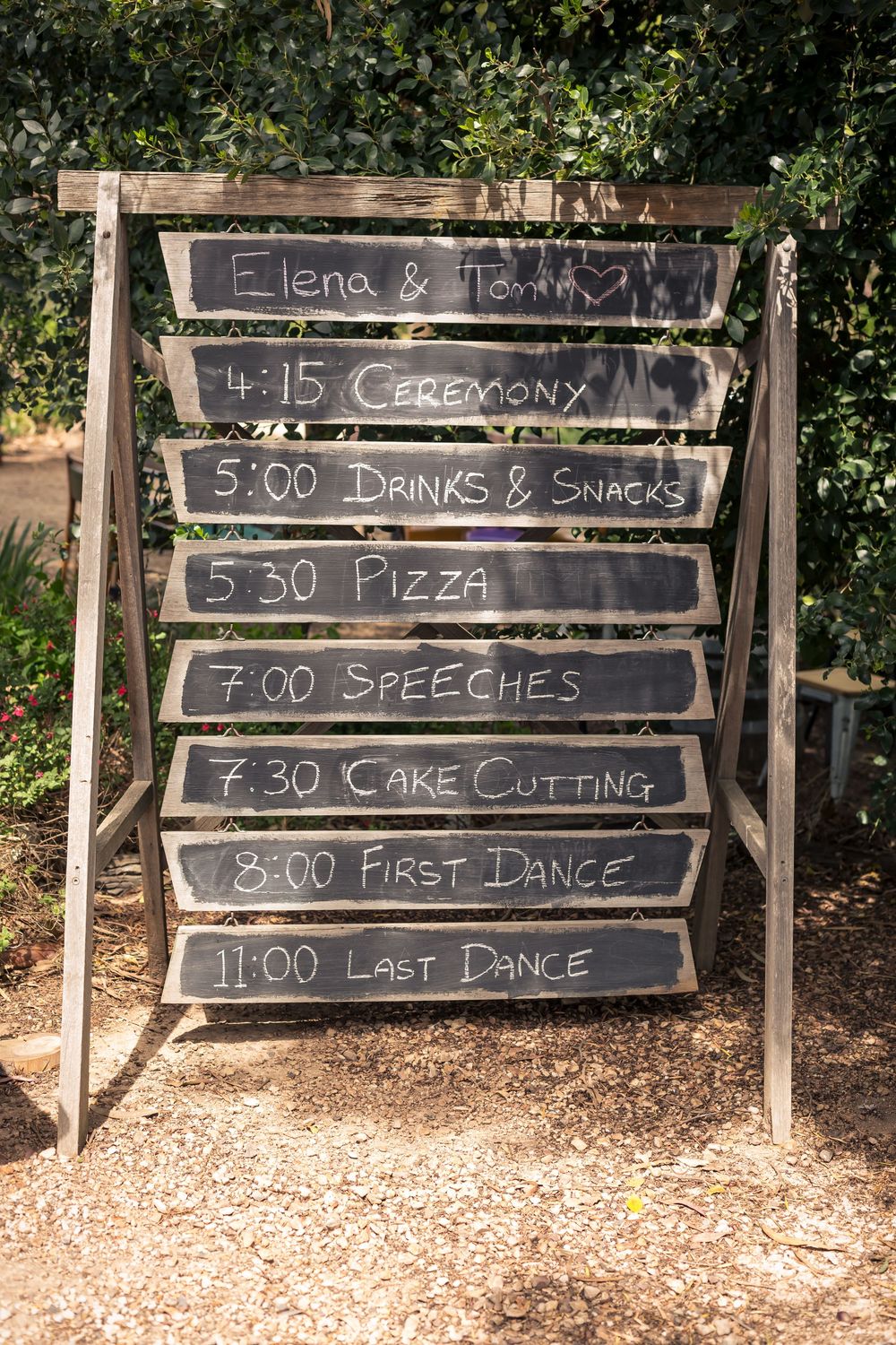 A rustic wedding timeline displayed on multiple chalkboards showing event schedule from ceremony to last dance.