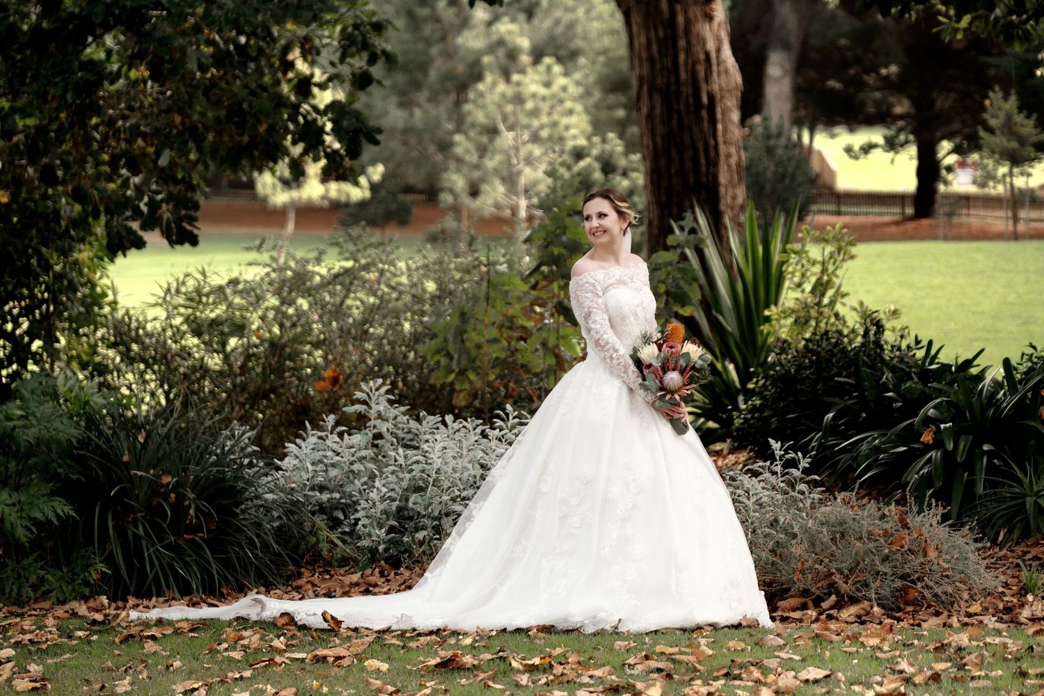 Wedding portraits captured in a lush garden setting with blooming flowers and greenery.