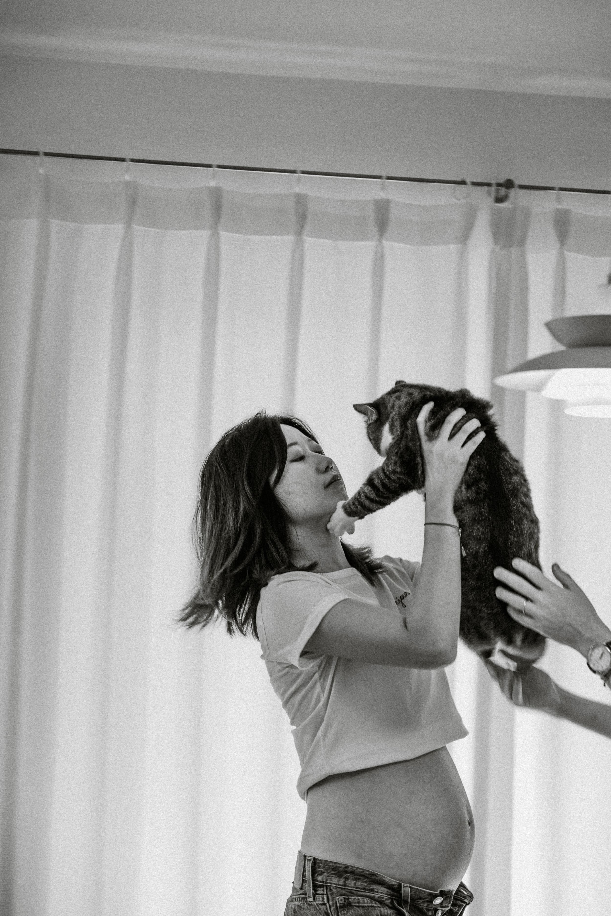 A playful series of black and white photos showing interaction with a cat indoors.