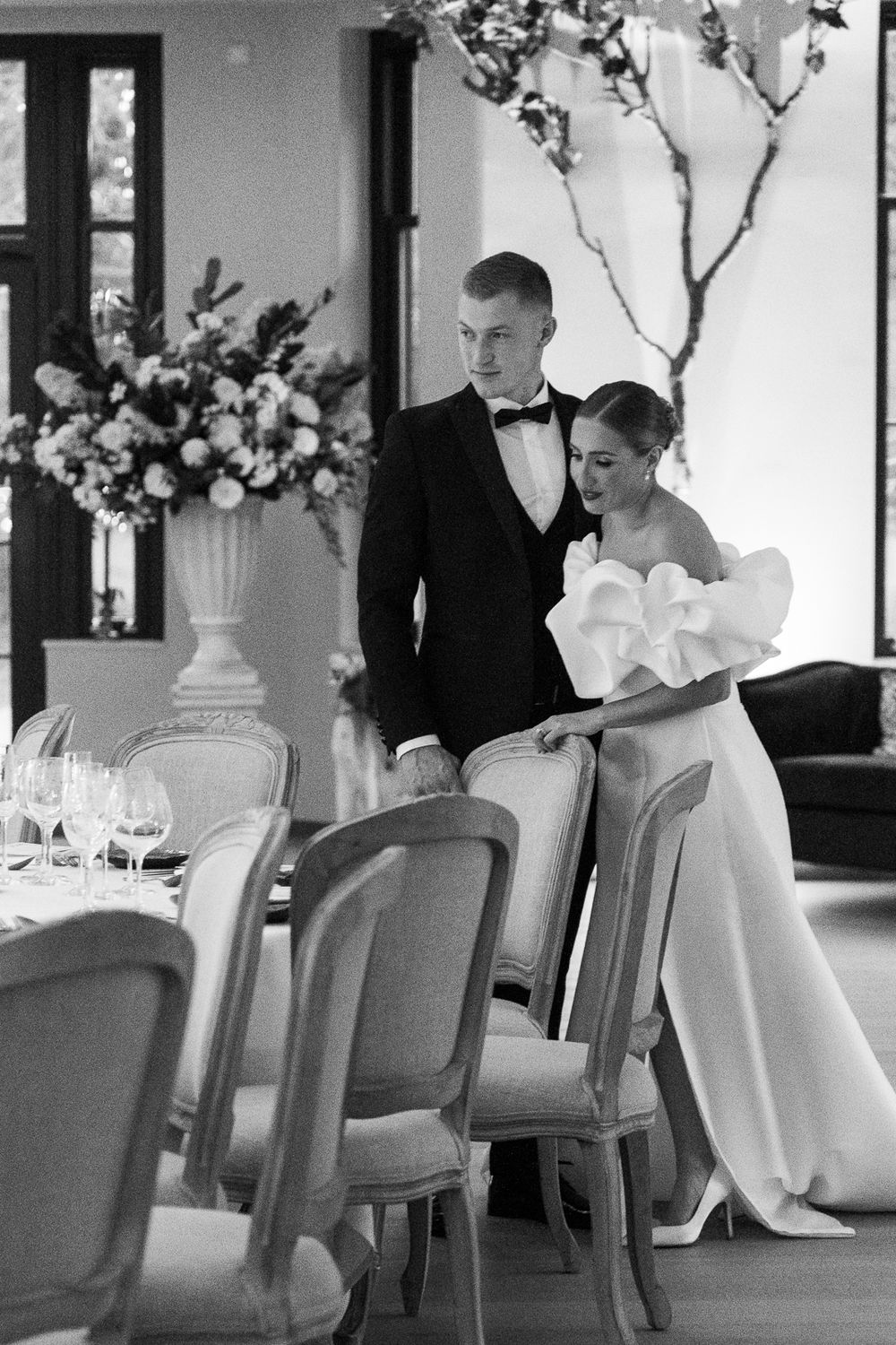 An elegant black and white photo of a couple seated at an upscale restaurant during a formal dining event.