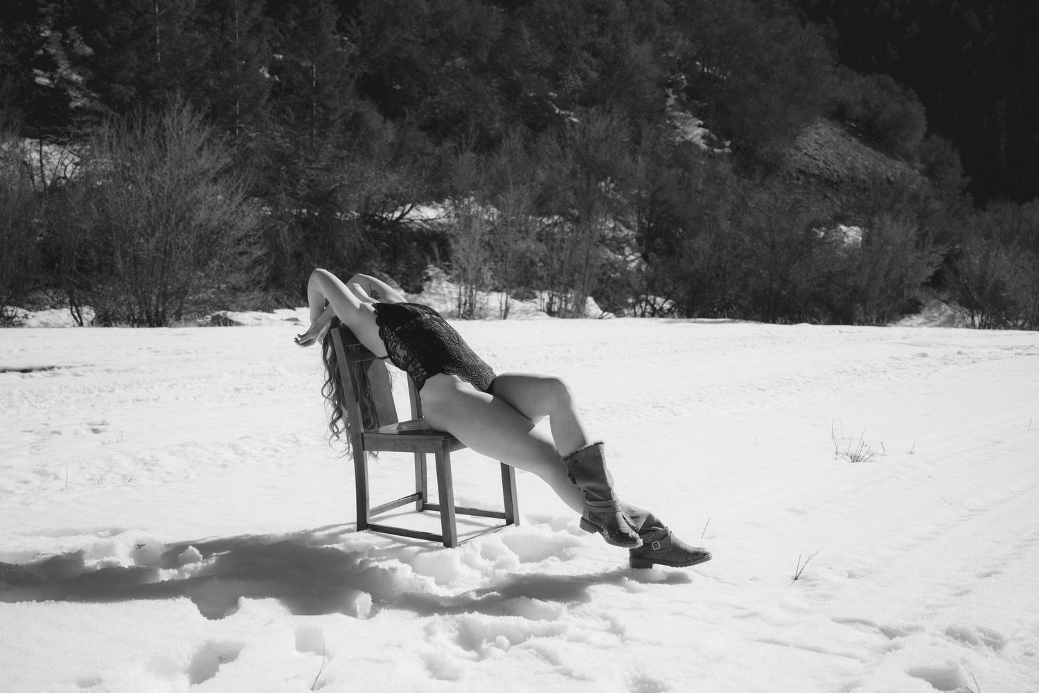 Empowering outdoor winter boudoir portrait of a woman in a snowy landscape.