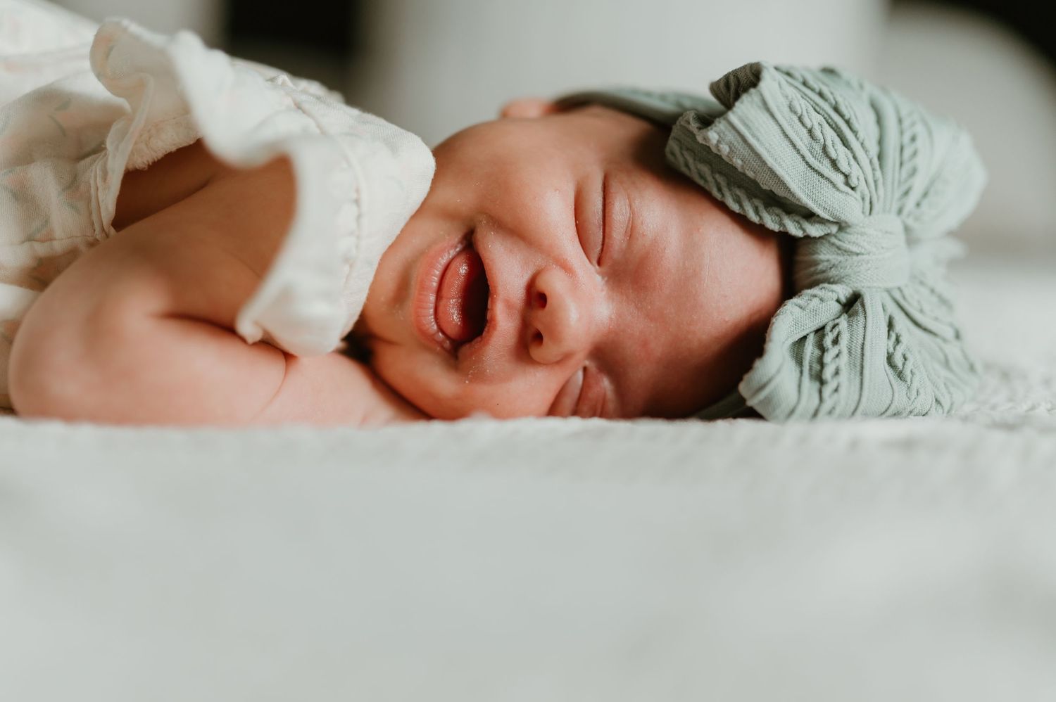Baby smiles a big, happy, smile during an in-home lifestyle newborn session in Wauwatosa, Wisconsin. Southeast Wisconsin newborn photography
