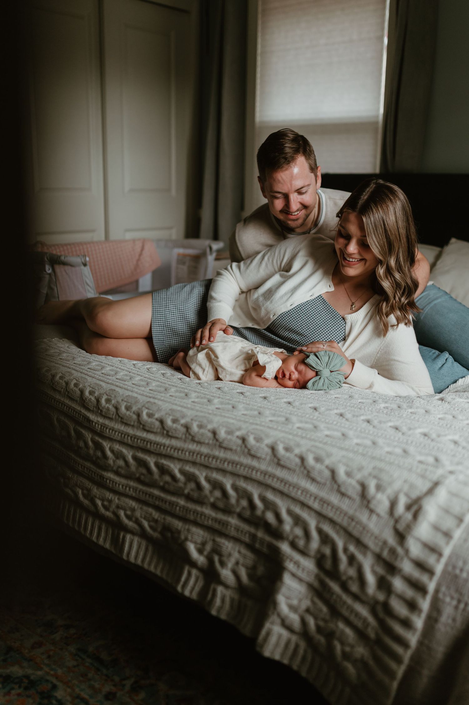 Parents rest with baby during an in-home lifestyle newborn session in Wauwatosa, Wisconsin. Southeast Wisconsin newborn photography