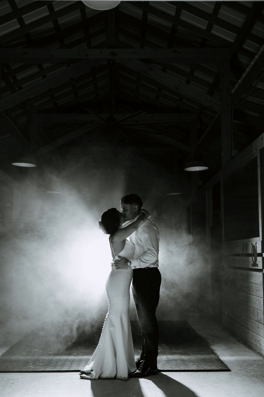 bride and groom inside barn at night, backlit with fog editorial shot at the ranch 22