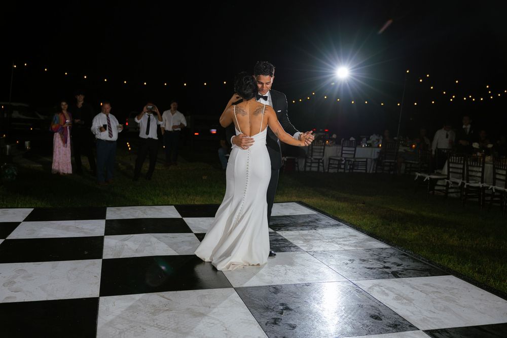 first dance picture of bride and groom on black and white checked dance floor at the ranch 22 lake worth