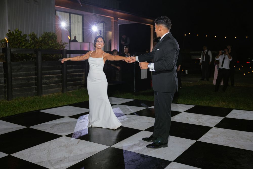 first dance picture of bride and groom on black and white checked dance floor at the ranch 22 lake worth