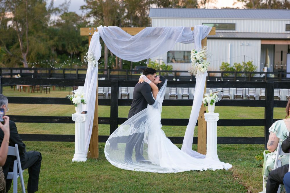 bride and groom first kiss at barn wedding at the ranch 22 in lake worth