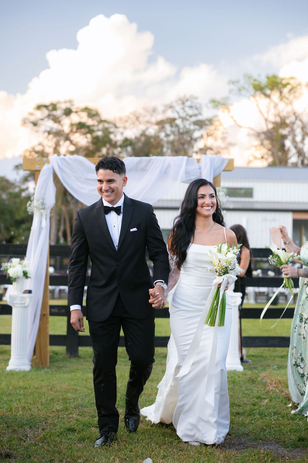 bride and groom waking down the aisle after getting married at barn wedding at the ranch 22 in lake worth