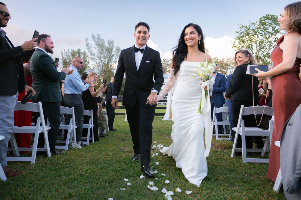 bride and groom waking down the aisle after getting married at barn wedding at the ranch 22 in lake worth