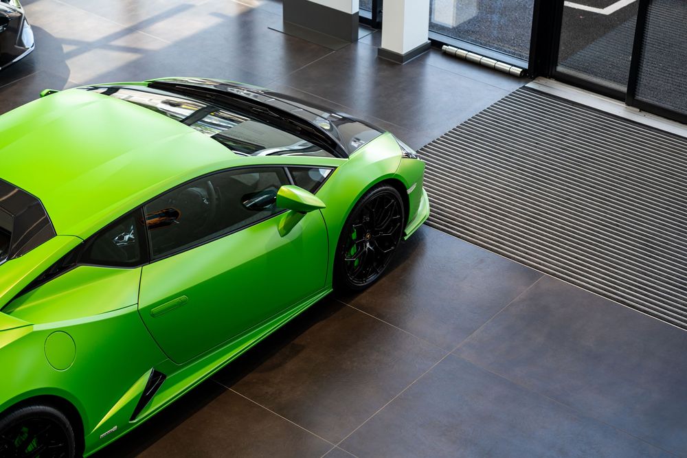 Lime green Lamborghini Huracan supercar displayed in a modern dealership.