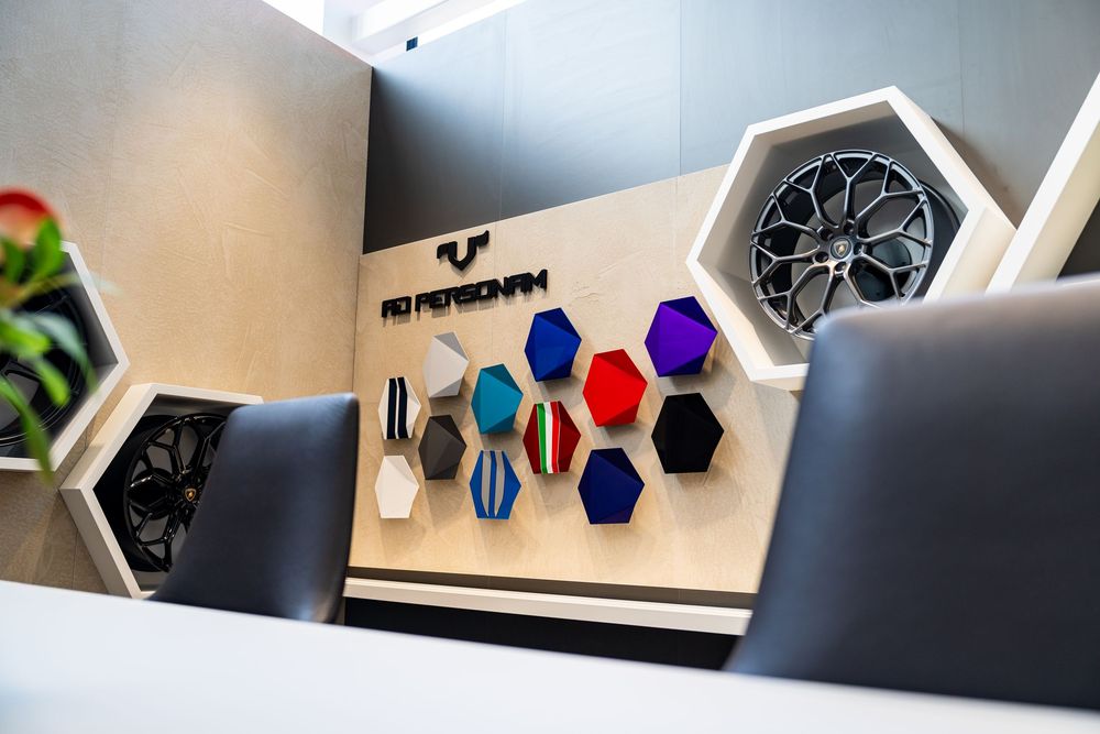 Lamborghini Ad Personam customization wall display featuring colorful hexagonal fabric and material samples.