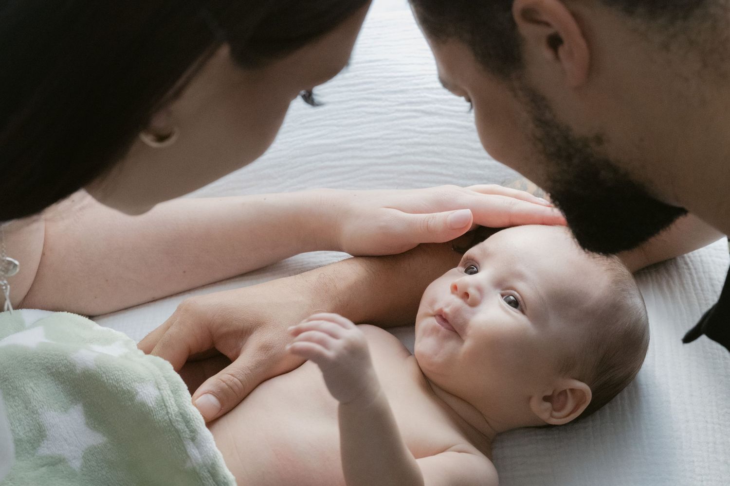 Mother gazing at sleeping newborn baby by window, intimate newborn photography North Vancouver