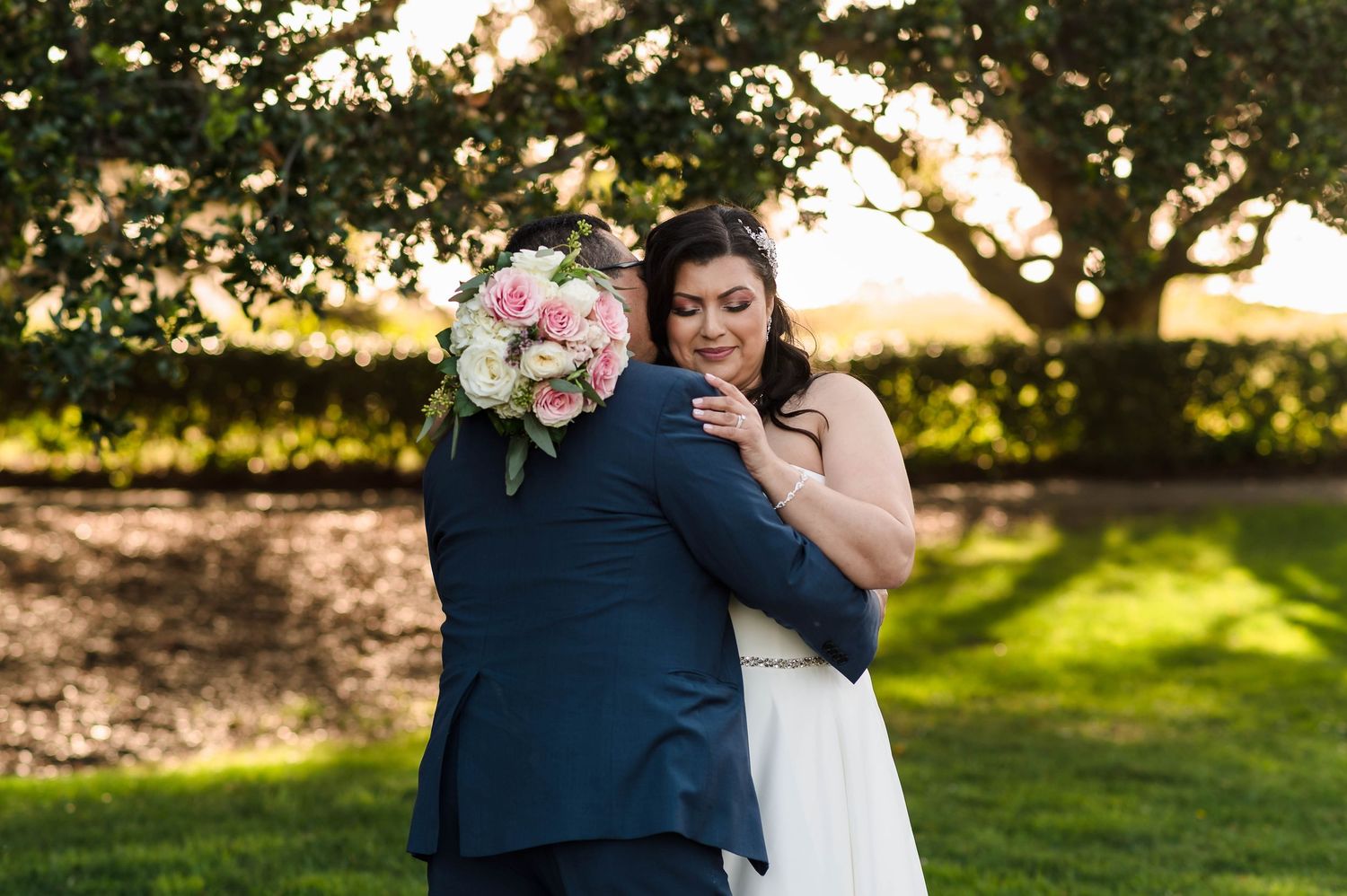 Bride and groom celebrating on a yellow vintage train car surrounded by tall redwood trees in a lush forest setting.