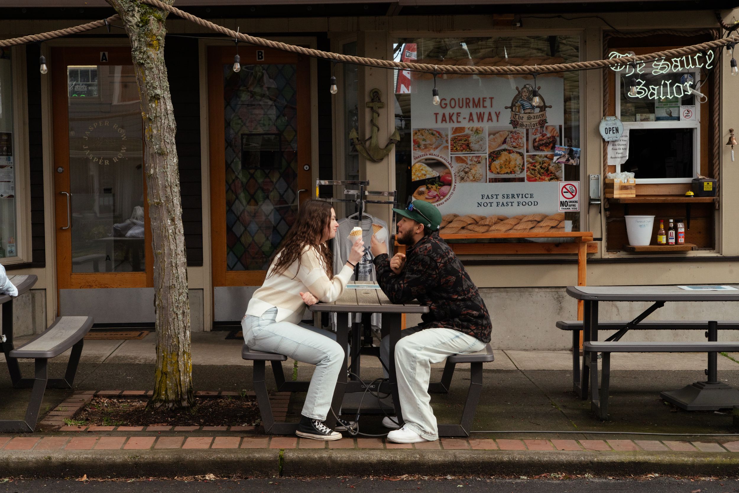 Cinematic moment of a couple sharing ice-cream in Kingston, WA during an engagement session, Captured by Savvy Photography.