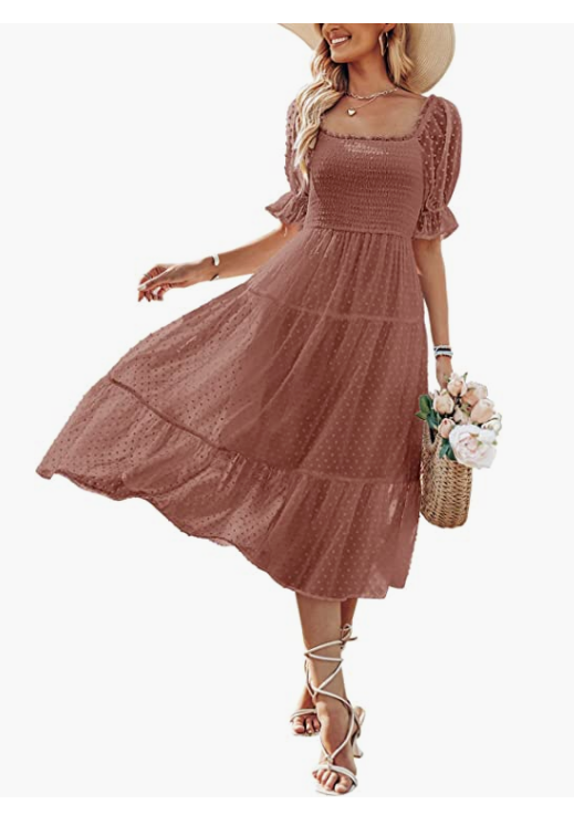 Woman wearing a dusty rose smocked bodice midi dress with puff sleeves, tiered skirt, holding a floral bouquet.