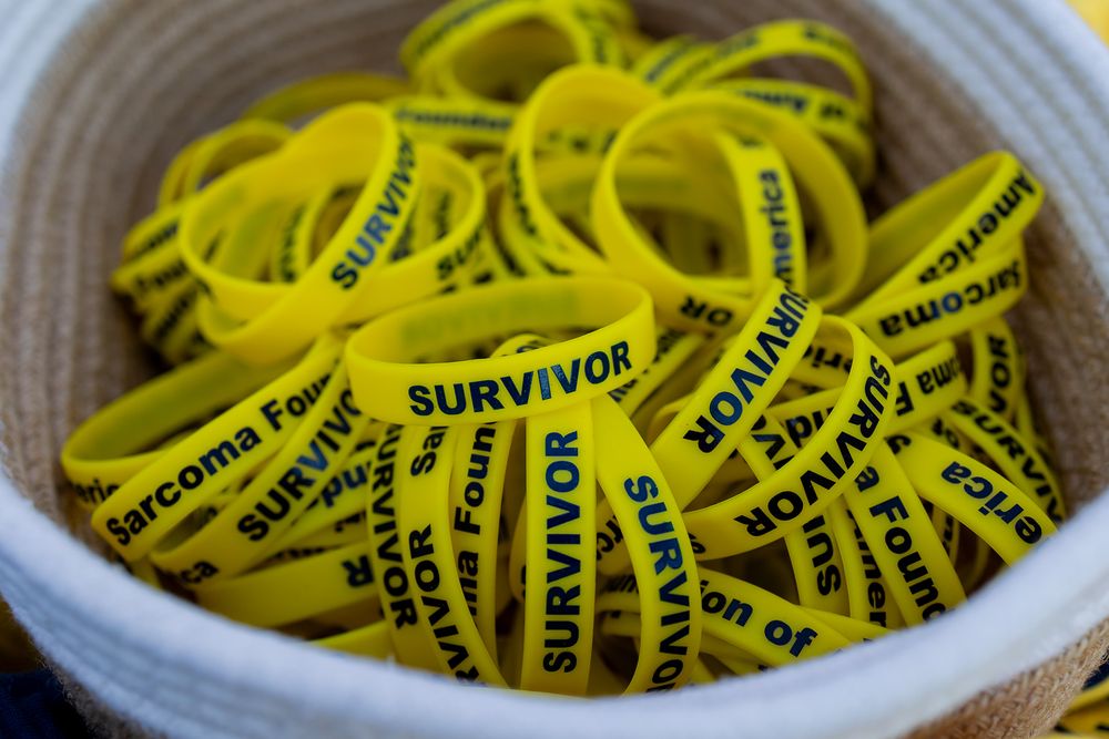 A basket filled with yellow silicone survivor wristbands from the Sarcoma Foundation.