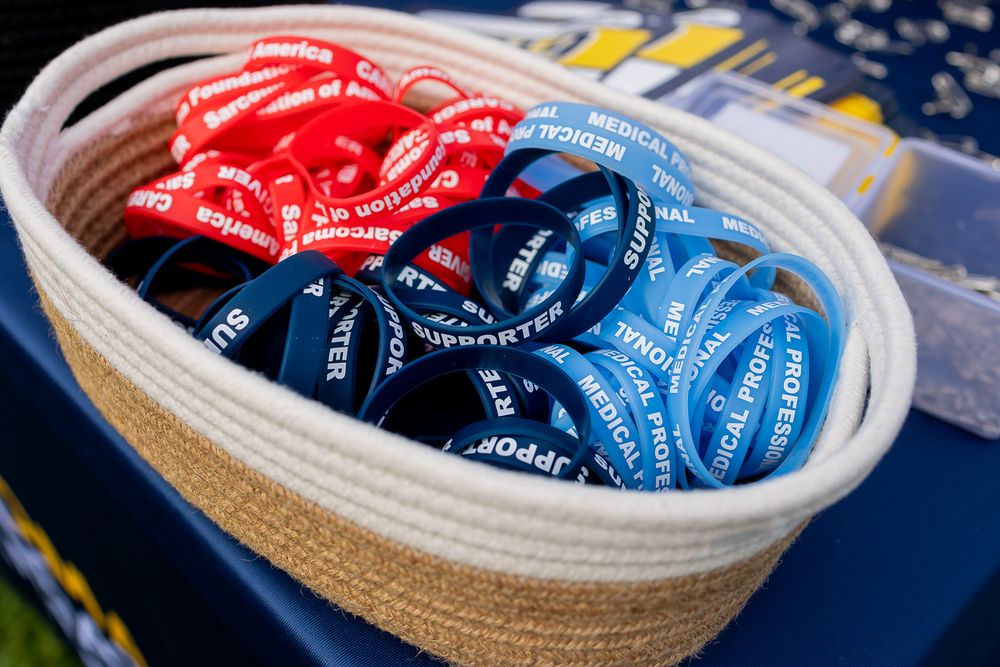 Basket filled with red and blue medical support wristbands at an event.