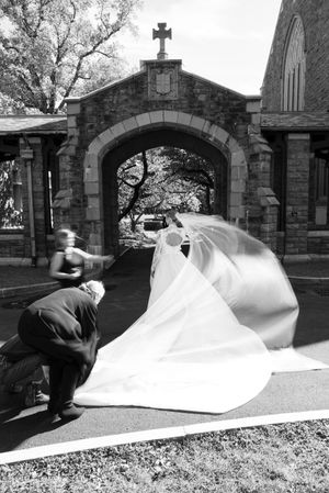 Black and white photo sequence showing a wedding dress train being arranged on stone steps in an architectural setting.