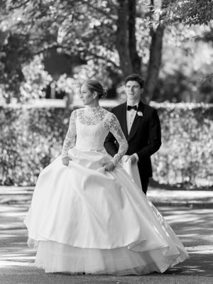 A black and white wedding portrait series showing a couple in formal attire posing together on a tree-lined path.