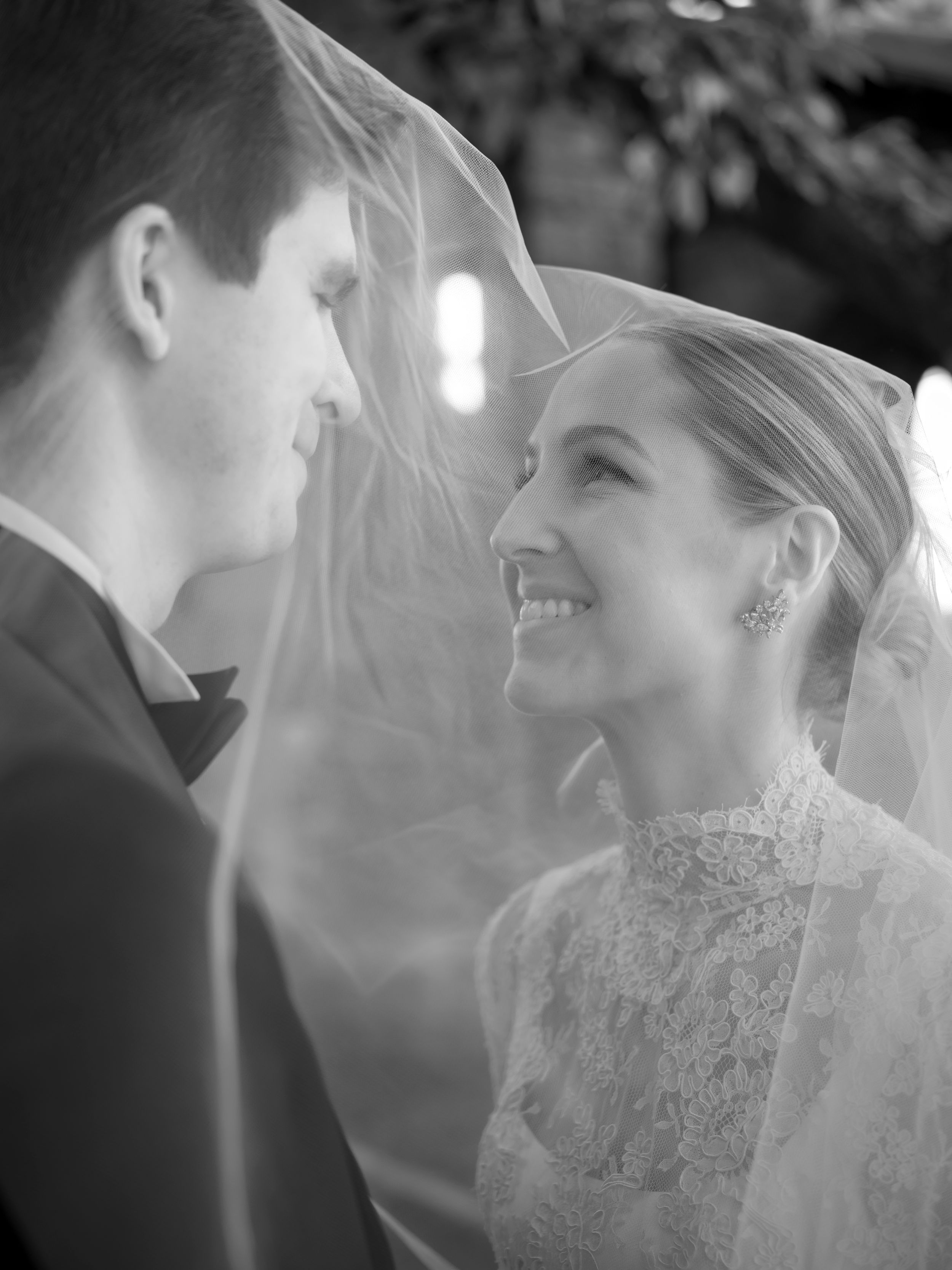 Close-up black and white sequence of a tender moment between newlyweds with bride wearing delicate lace veil.