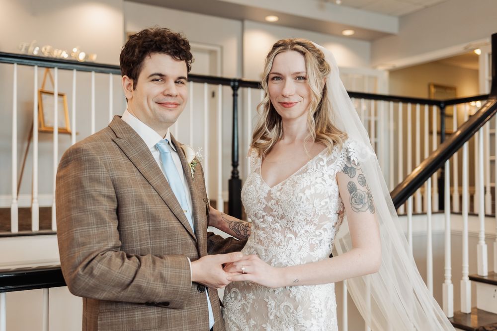 Smiling bride and groom holding hands in elegant wedding attire on their special day.