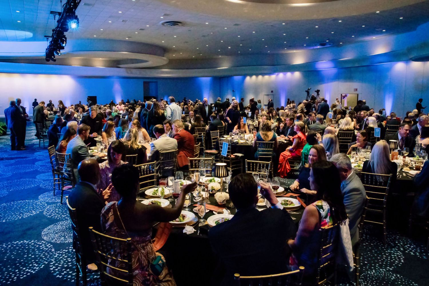 Elegant Diamond Circle awards banquet with guests seated at round tables in a blue-lit ballroom.