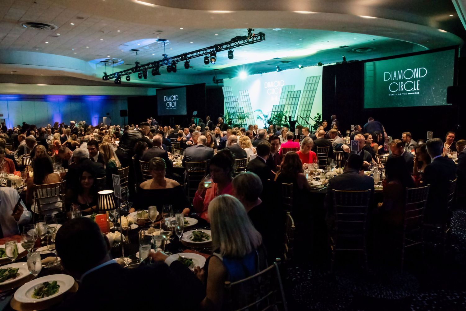 Large crowd of attendees gathered at the Diamond Circle gala dinner event in a spacious conference ballroom.