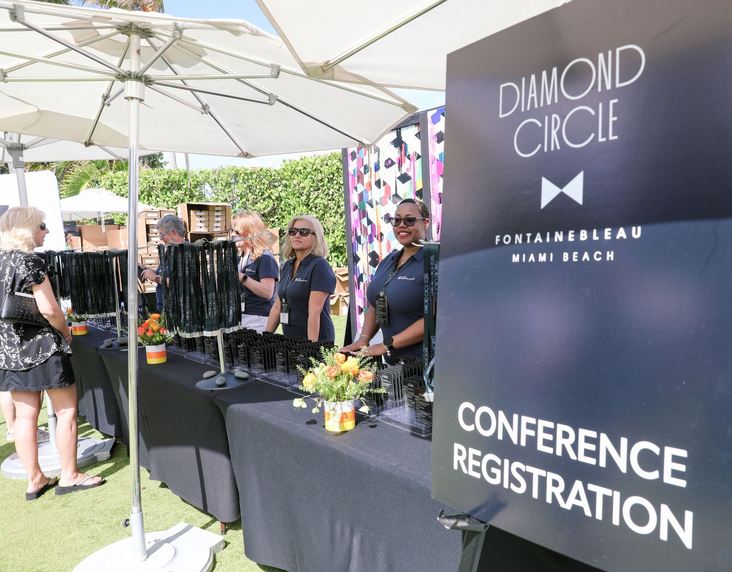 Diamond Circle Fontainebleau Miami Beach conference registration booth with staff at outdoor event.