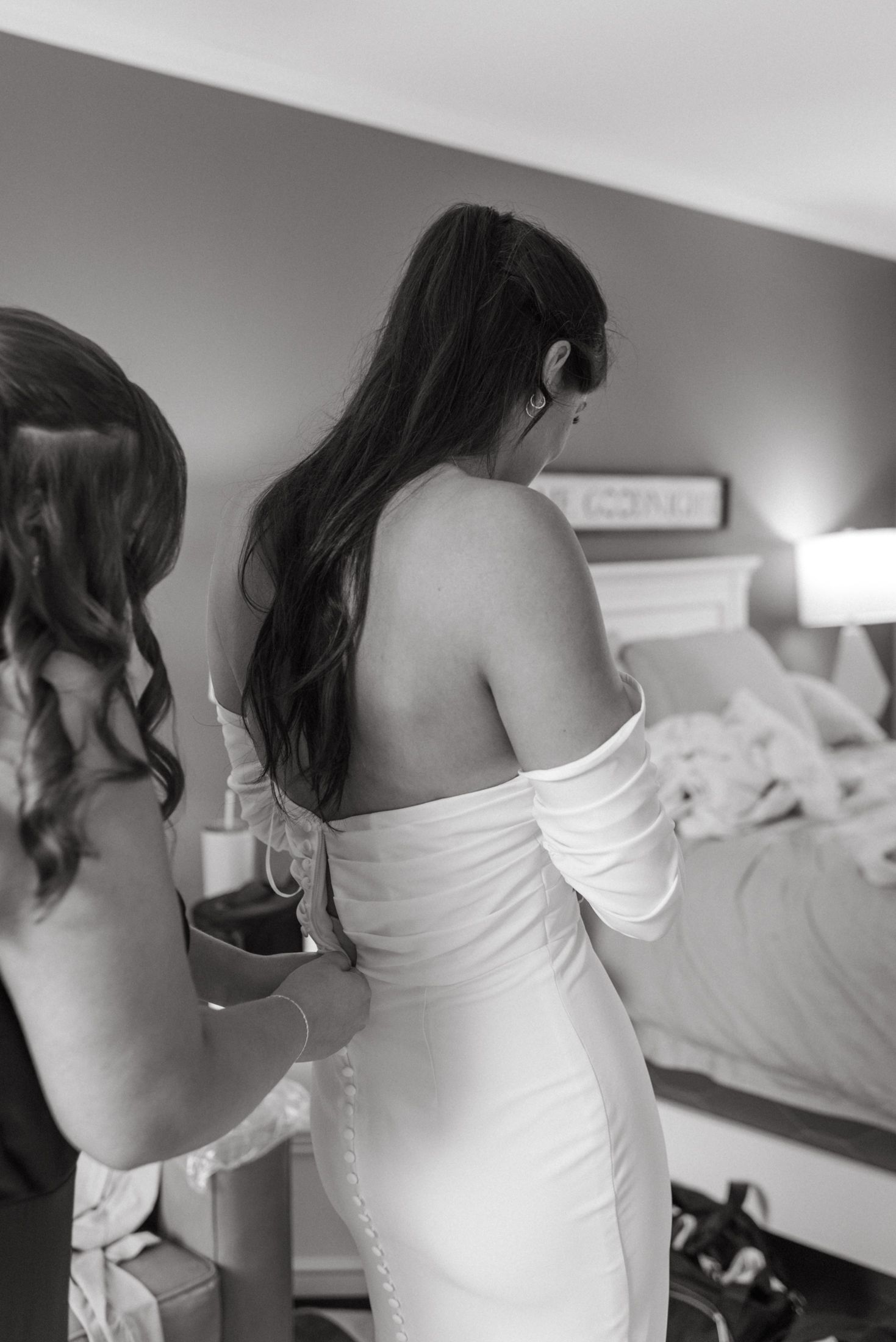 A woman in a white wedding dress is being laced up from behind in a series of sequential black and white photos.