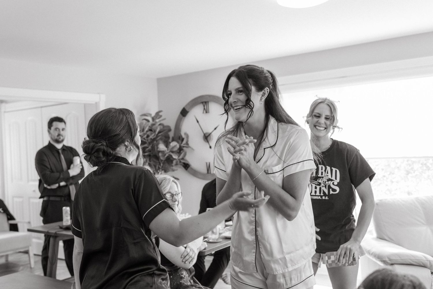 Bride getting ready with bridesmaids in a bright room, sharing a joyful moment before the wedding ceremony.