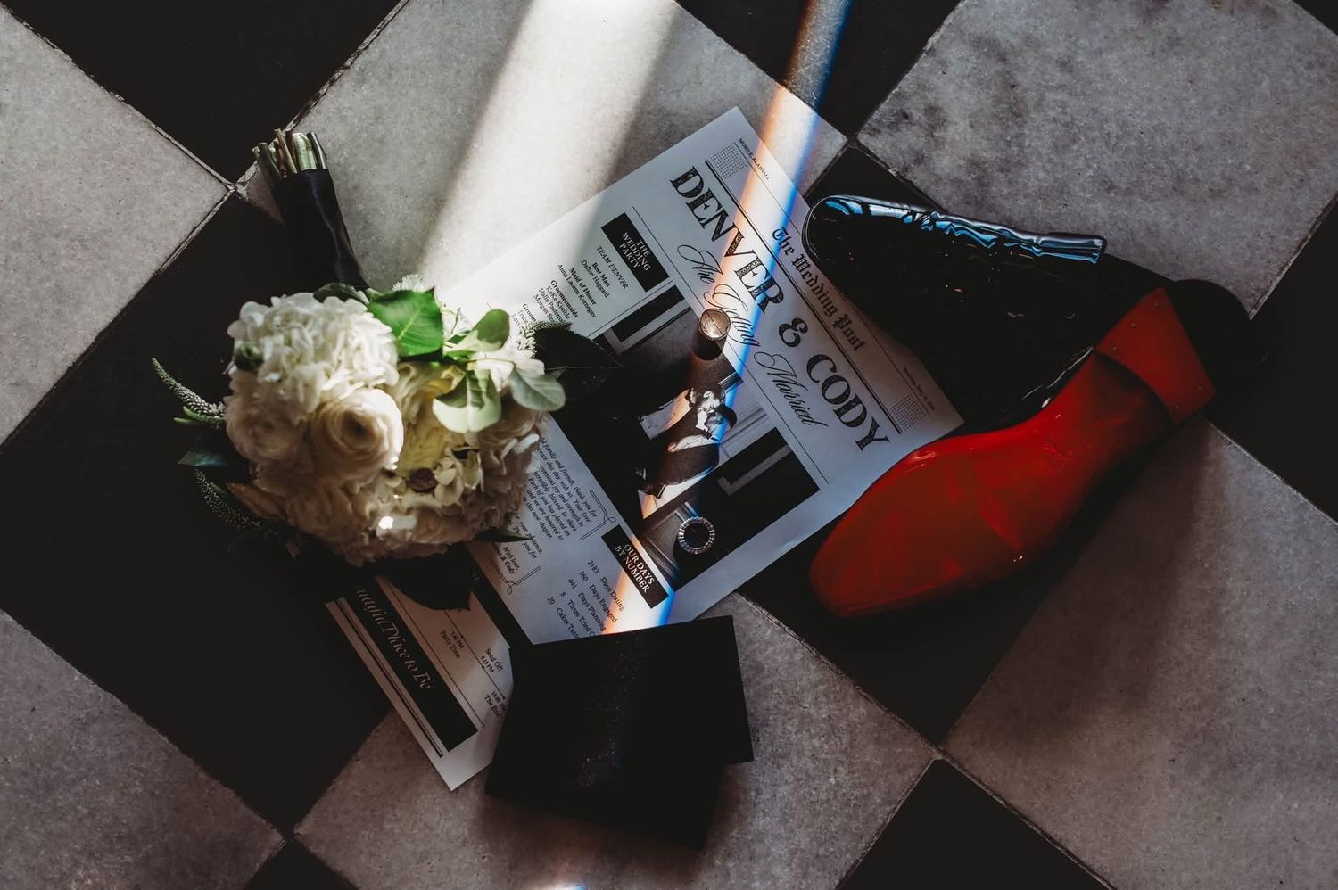 Wedding bouquet and red-soled Louboutin heels on a checkered floor with a magazine.