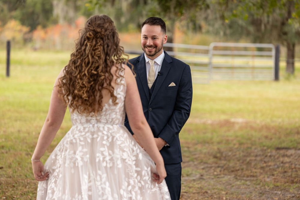 Bride and groom share a romantic moment outdoors in a rustic setting with trees in the background.