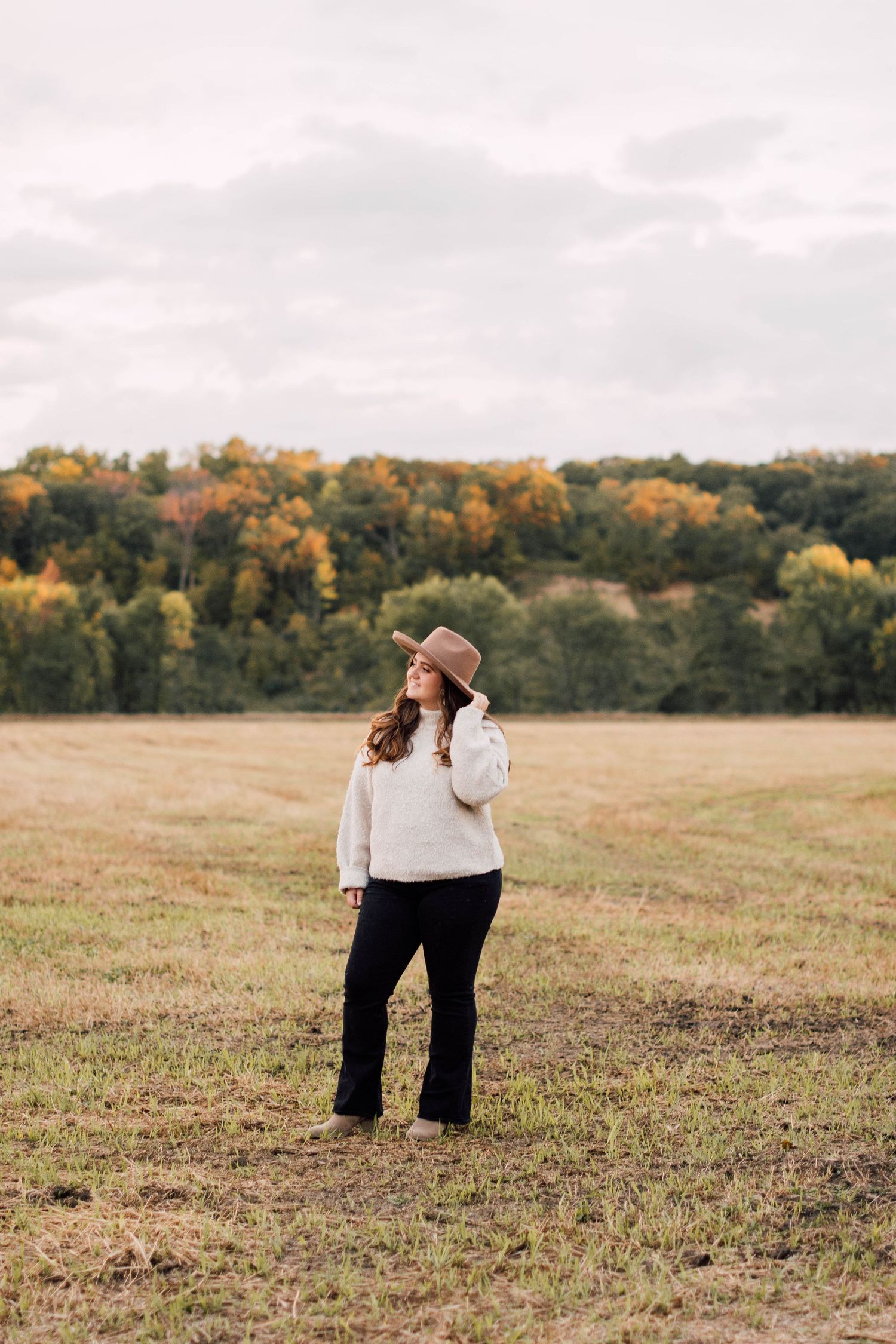 A series of outdoor portrait shots in a grassy field with autumn trees in the background.