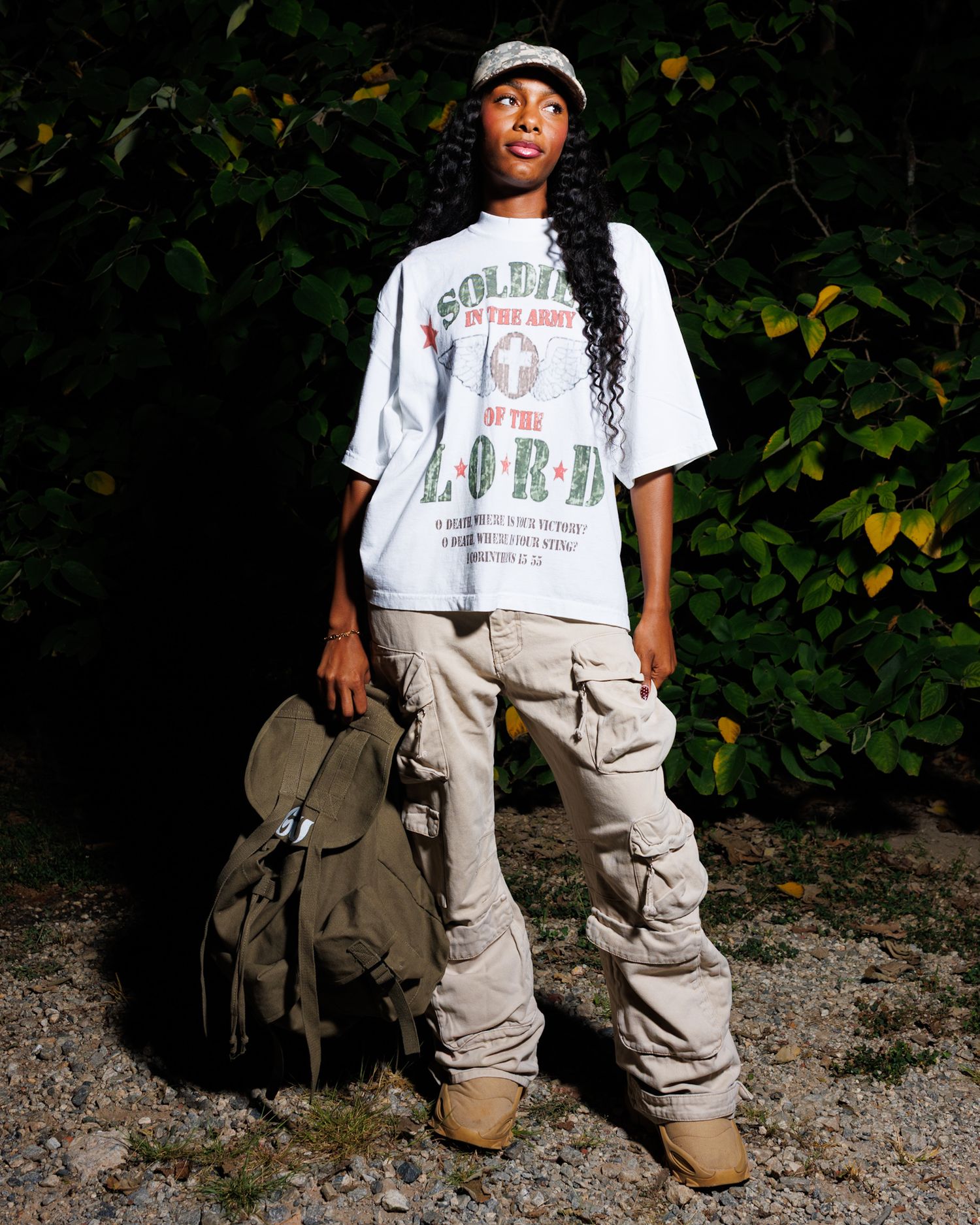 A person wearing a white t-shirt and khaki cargo pants poses in front of dark foliage in a series of casual shots.