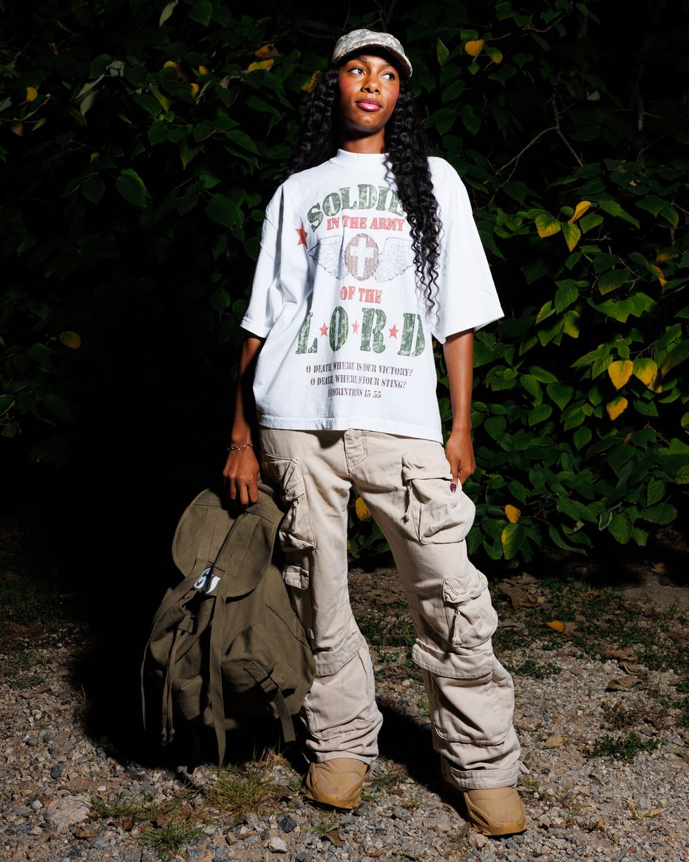 A person wearing a white t-shirt and khaki cargo pants poses in front of dark foliage in a series of casual shots.