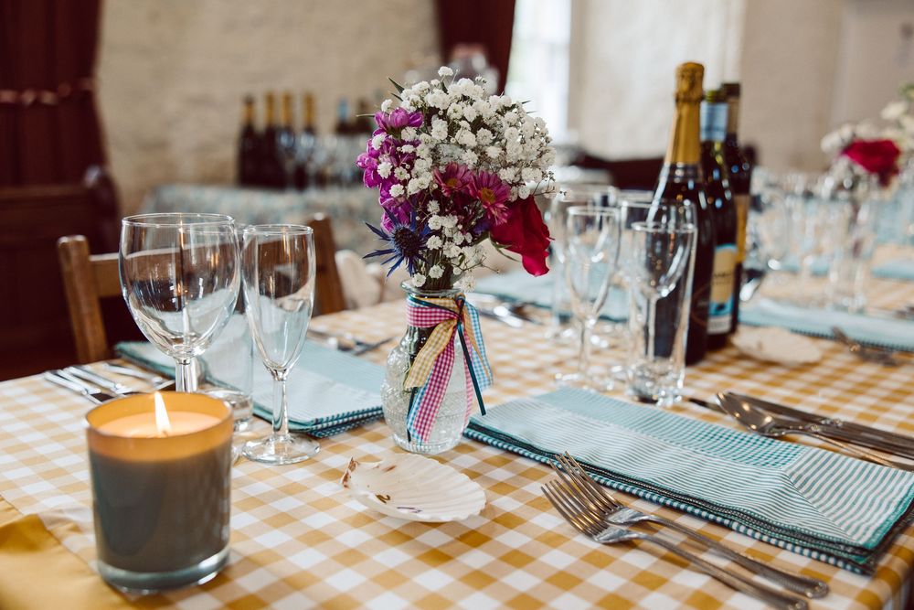Elegant table settings with wine glasses and floral centerpieces at a formal dining event.