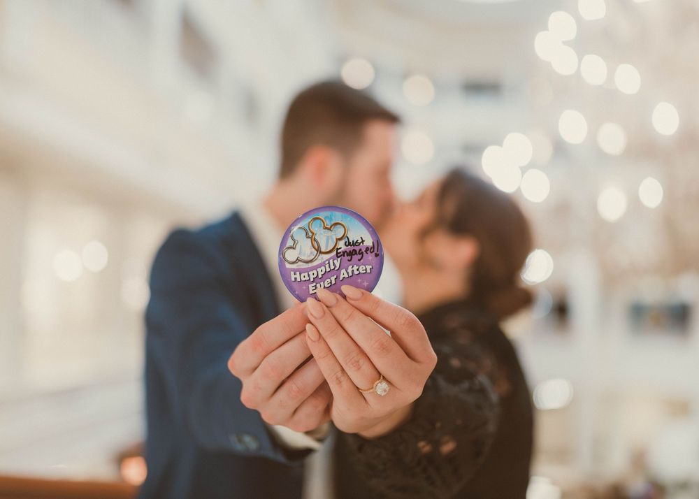 Disney-inspired wedding photography, couple kissing at Disney Grand Floridian in Central Florida. Happily Ever After buttons.