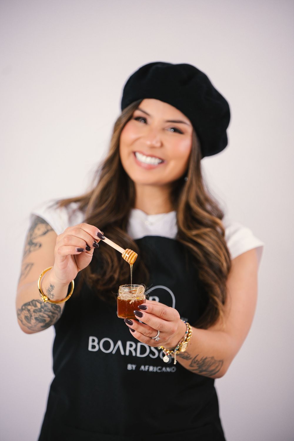 Person in black shirt and beanie holds maple syrup bottle in creative product photography series.