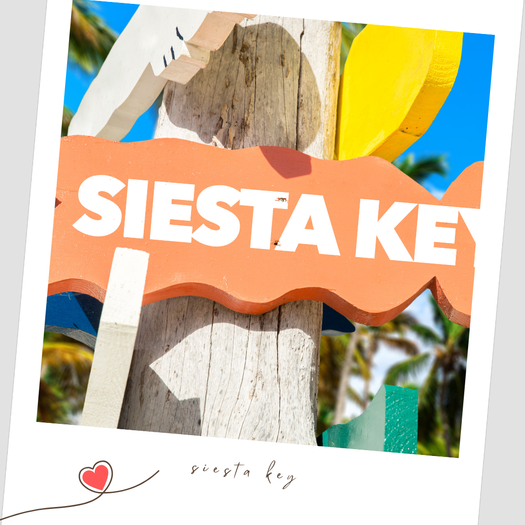 Colorful wooden beach signs with text 'Siesta Key' against blue sky and palm trees.