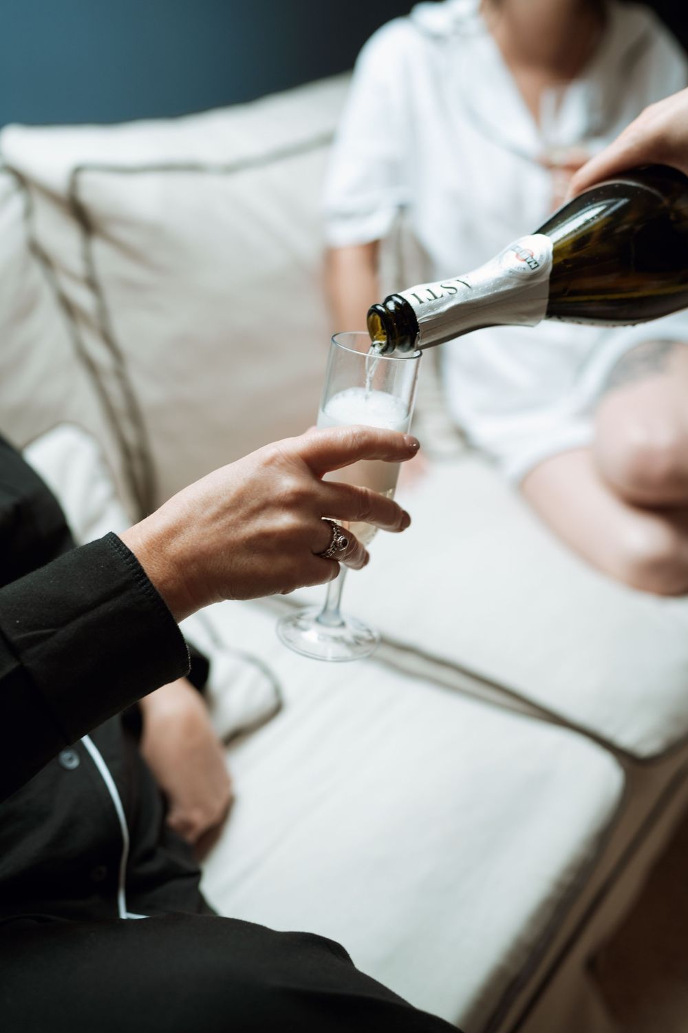Hands pouring champagne into elegant glasses during a wedding celebration.