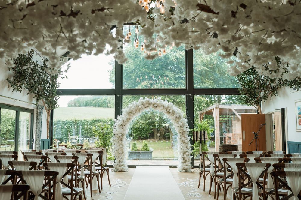 Elegant wedding reception venue decorated with hanging floral arrangements and natural lighting.